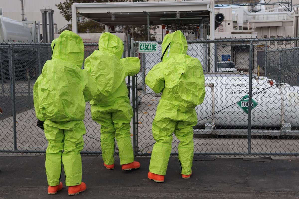 3 members of the hazardous materials team in Hazmat suits