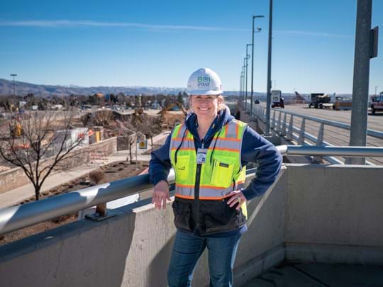 woman wearing hard hat and reflective vest with background of Boise foothills
