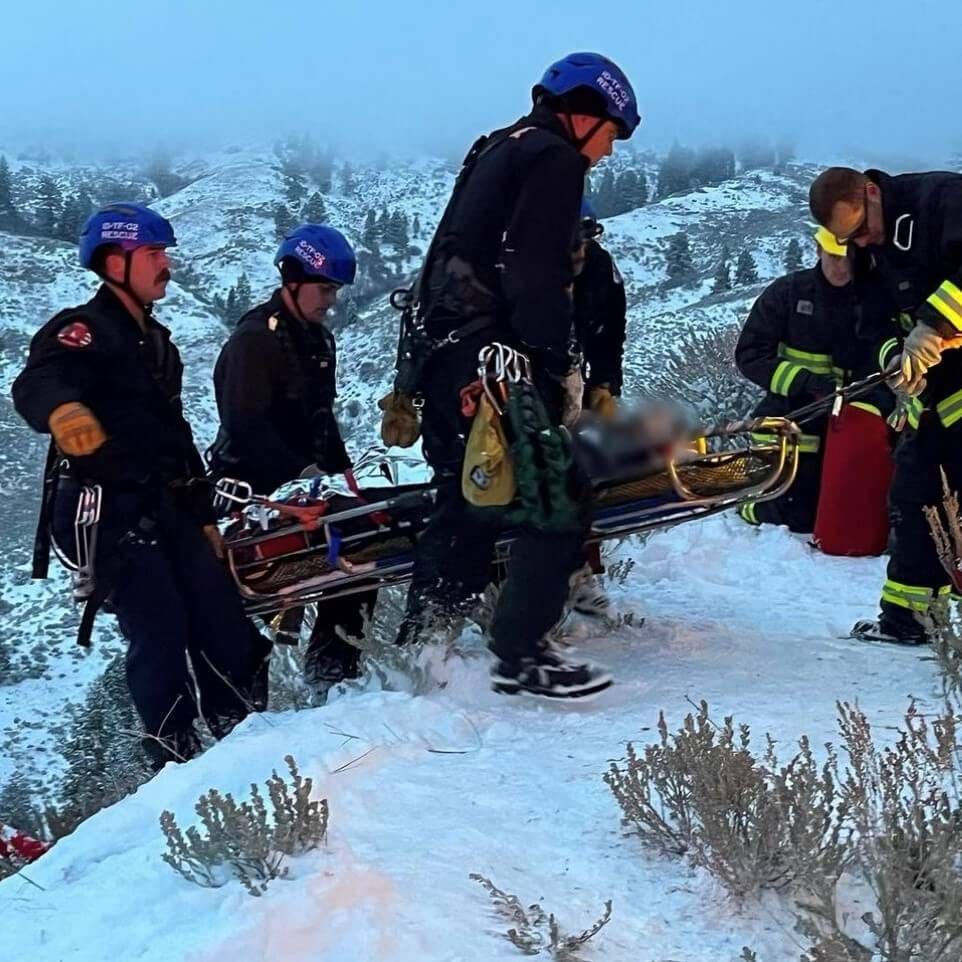 Firefighters rescuing a person that had driven off of a cliff.