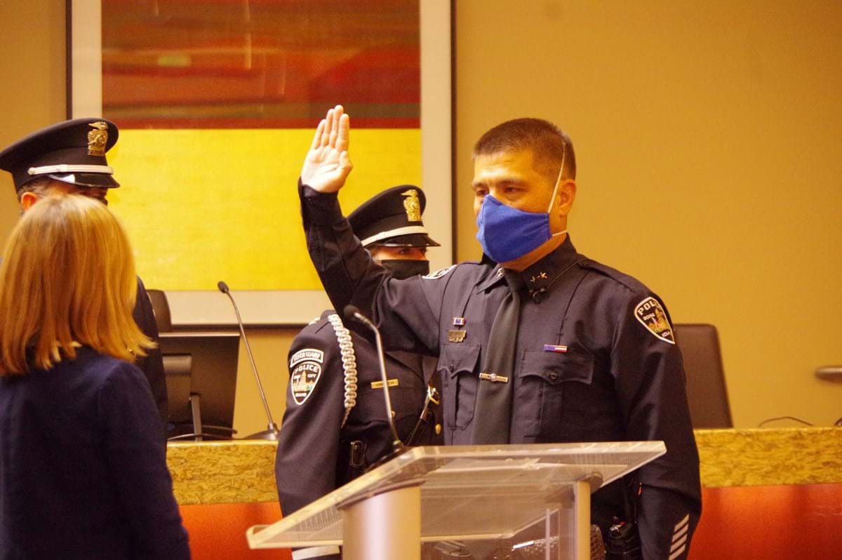 Chief Lee raising hand as he is sworn in by Mayor McLean