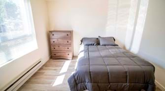 Bedroom with full size bed and dresser with large window