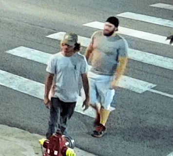 Two men wearing hats walking across a cross walk
