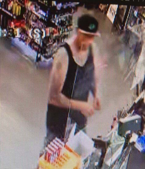 man with black tank top and hat in store