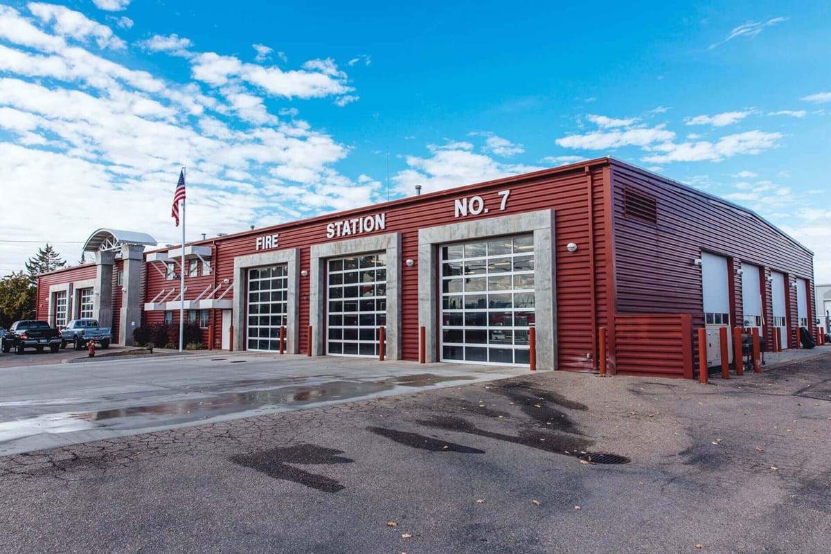 Large fire station building with three garage bays and bright blue sky