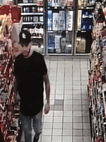 man with black shirt and black hat walking inside gas station