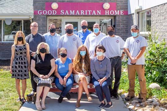 A group of employees at the Good Samaritan Home stand in front of the building