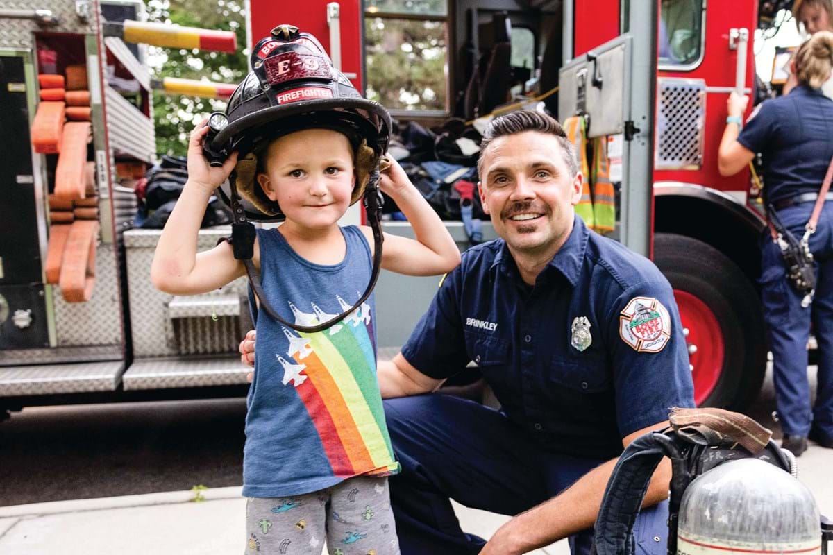 Firefighter and a young boy wearing a firefighter's hat