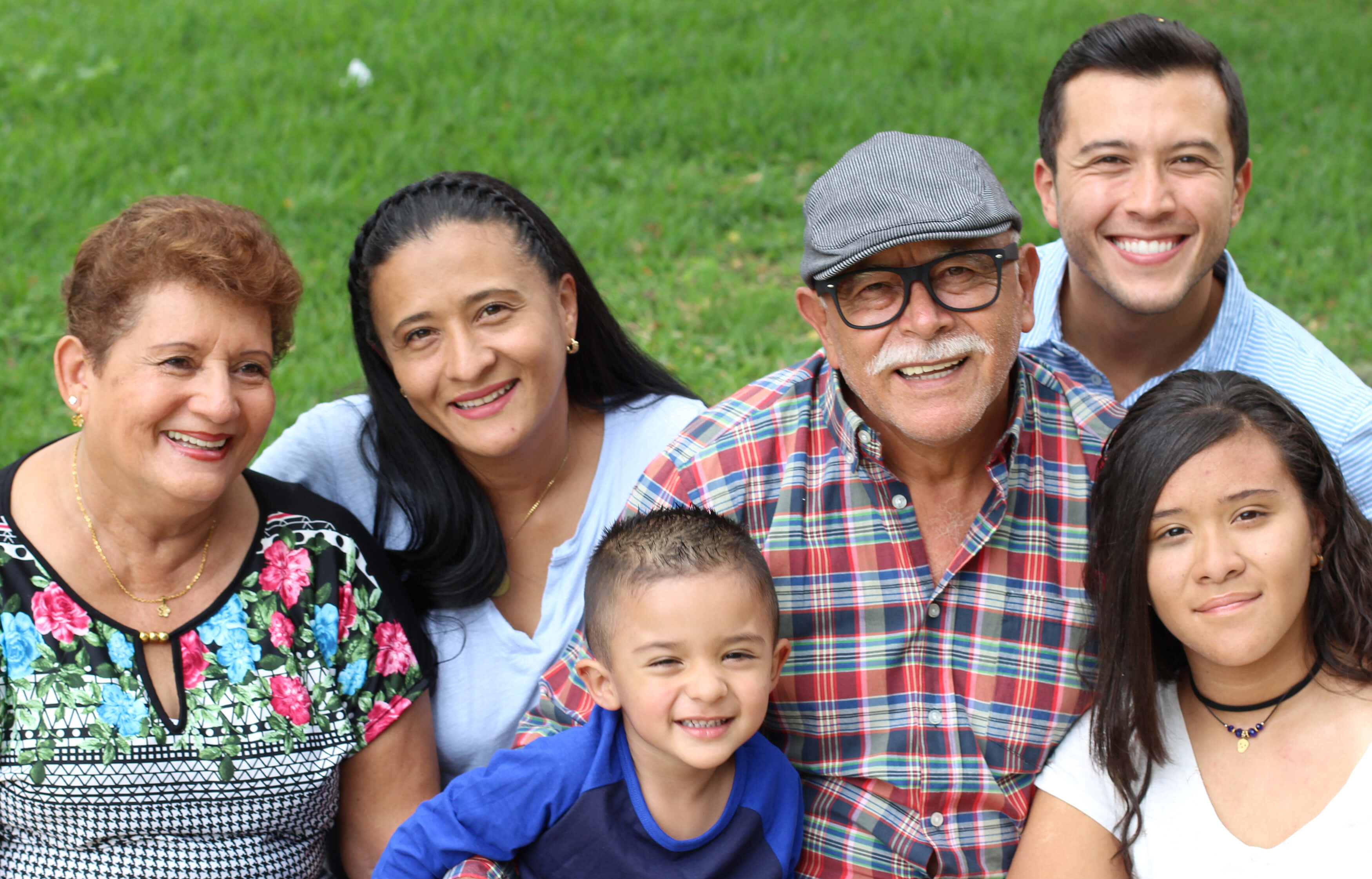 A group of family members in front of green grass.