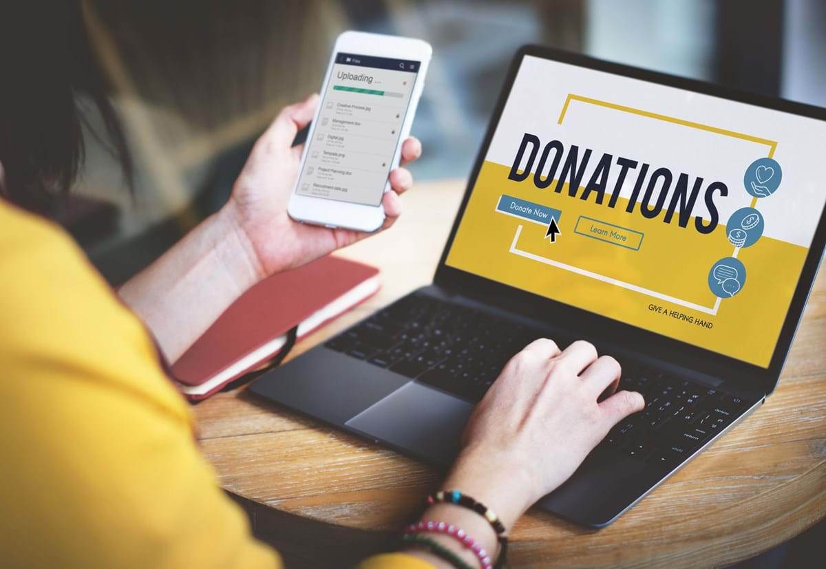 Person making an online donation to charity on a laptop.