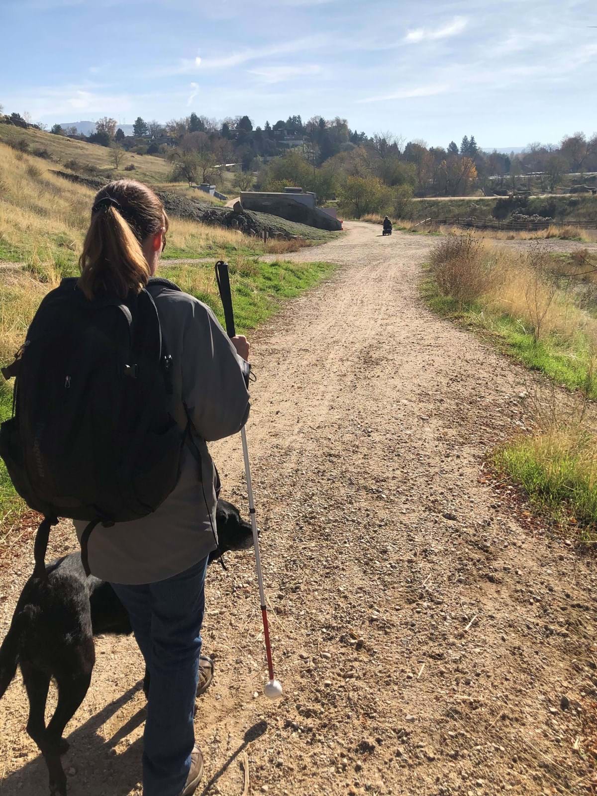 woman walking on trailhead with support animal