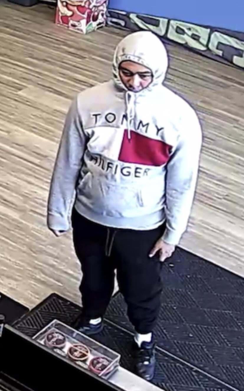 man wearing a Tommy Hilfiger sweater with hood over his head scrunched up at a business