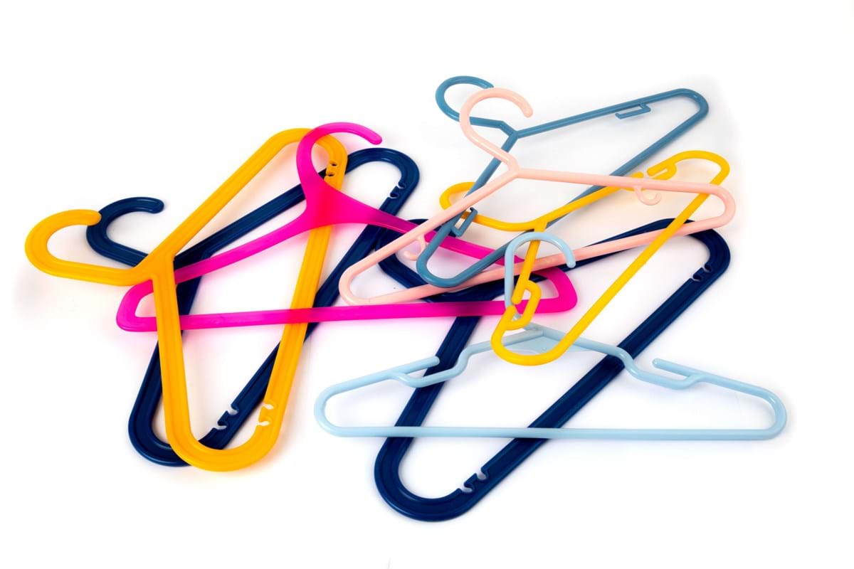 colored hangers spread out on white background
