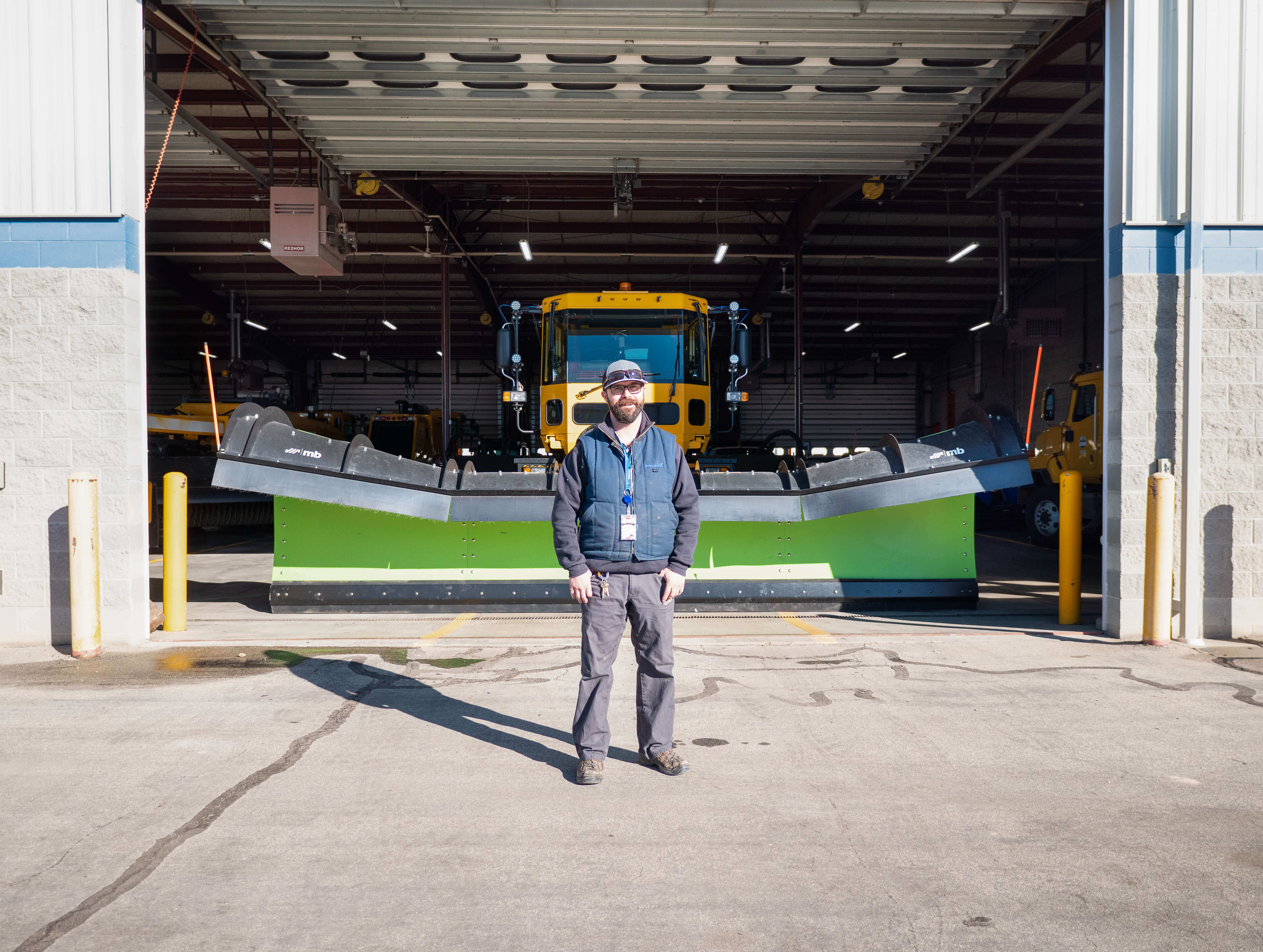Airfield technician standing in front of a hanger. 