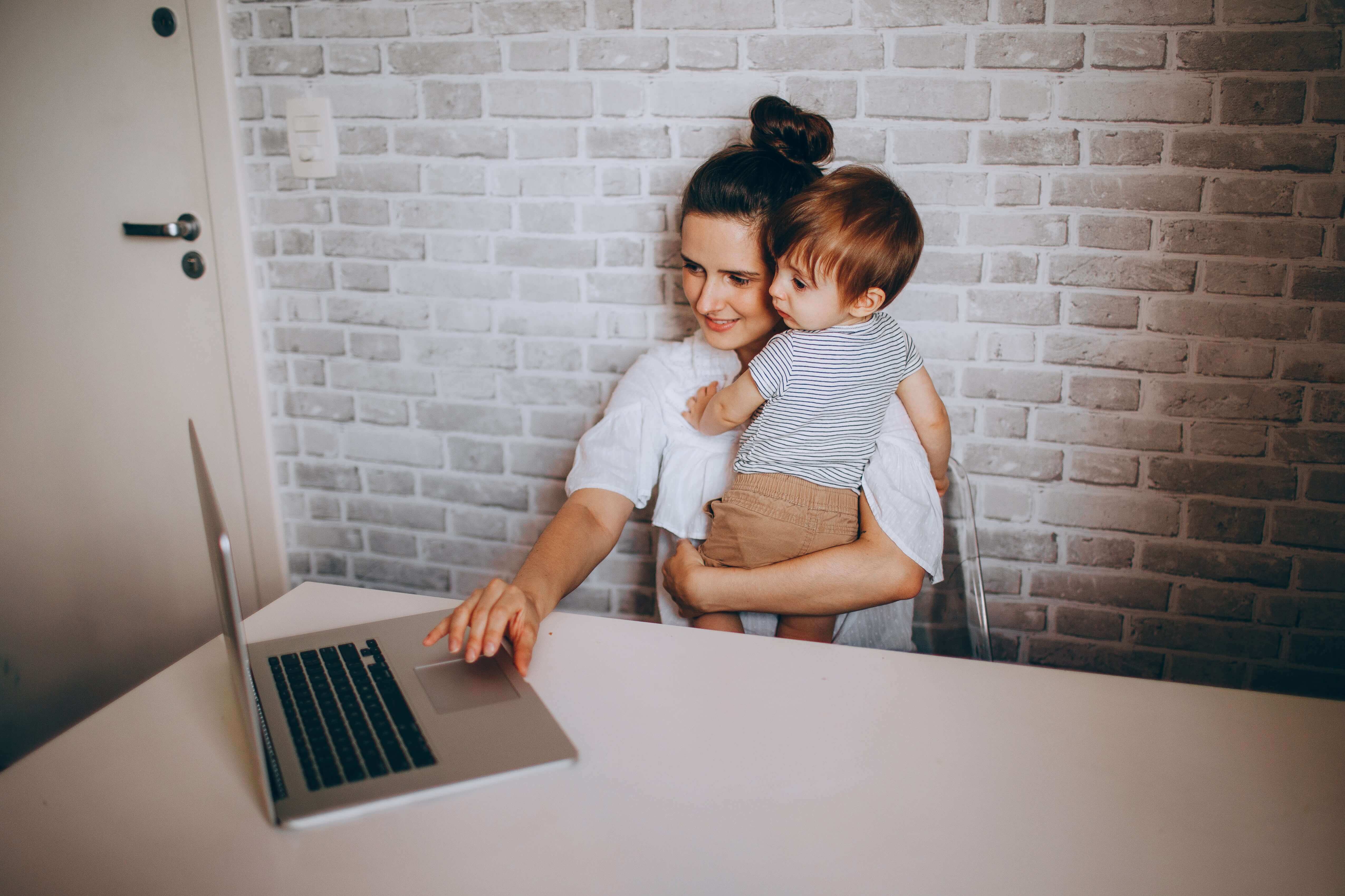 Woman sitting with child on her lap paying bills.