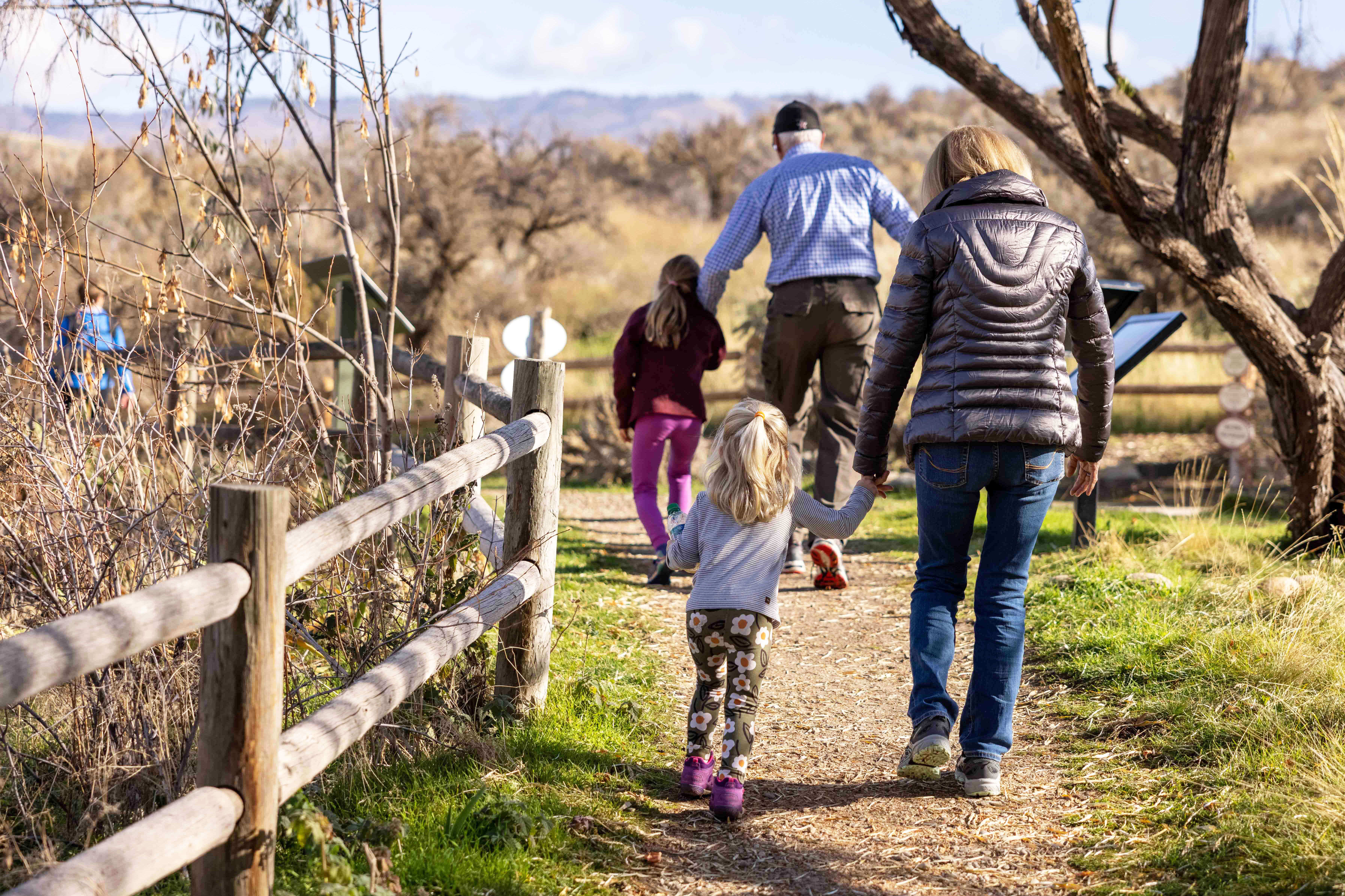 A family of four walks along a path at the Foothills Learning Center