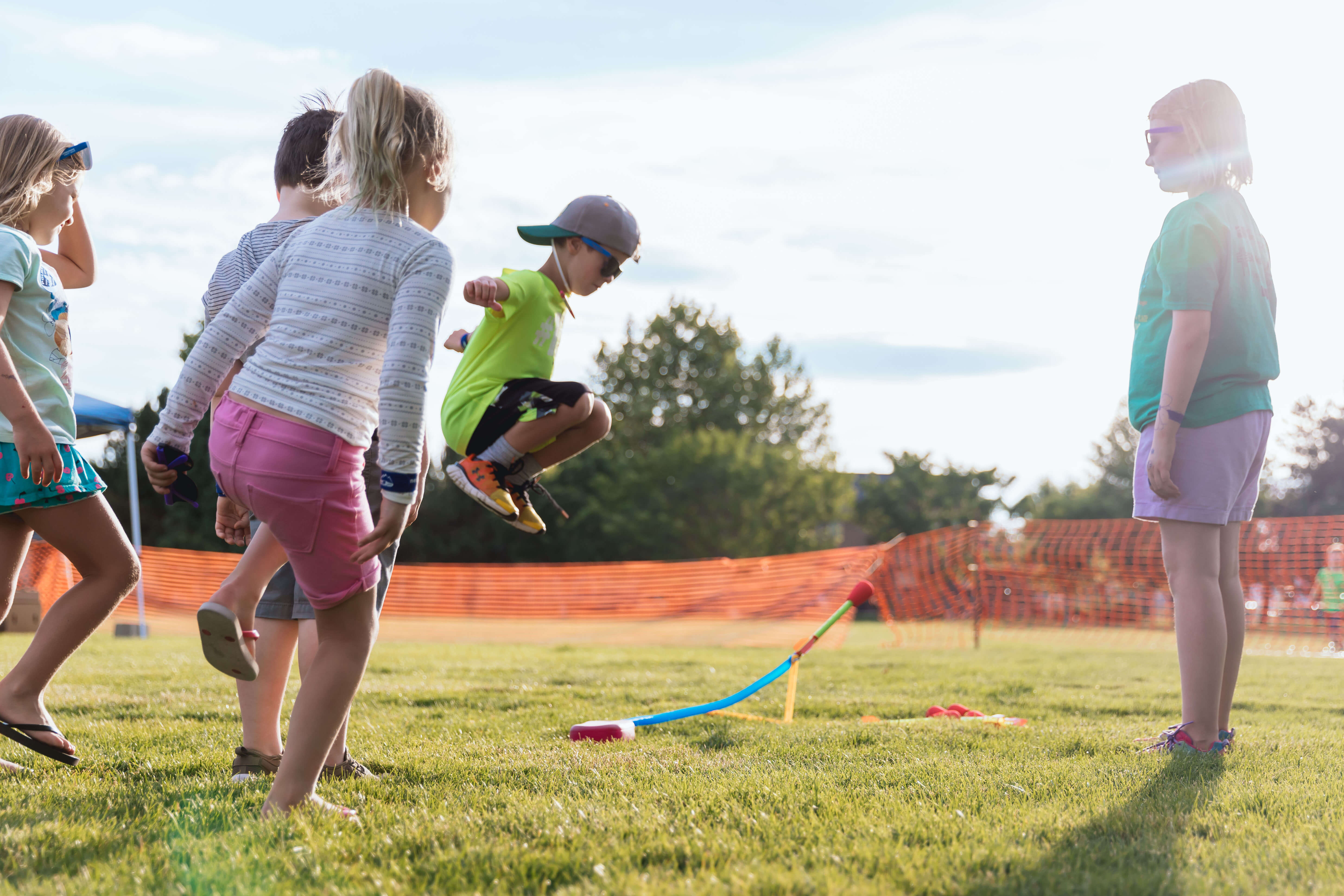 Kids playing in a park jumping over a rope