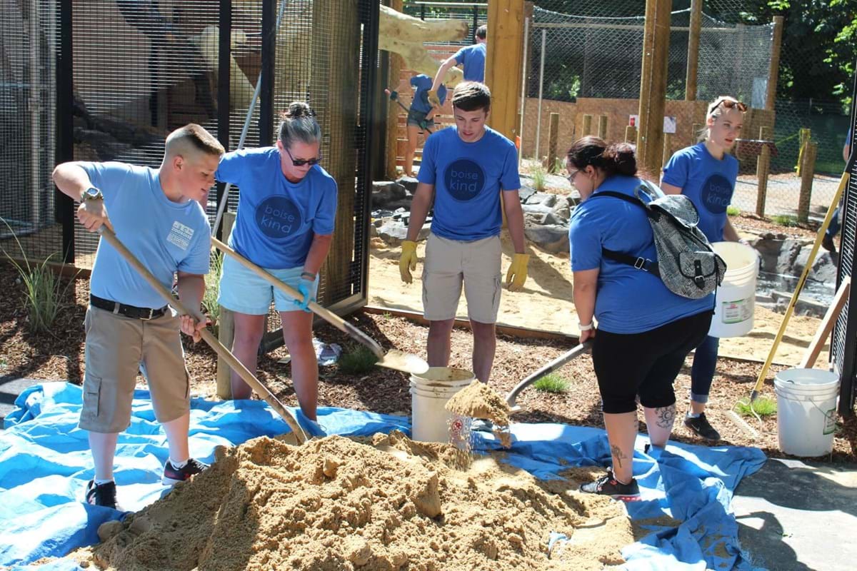 group wearing Boise Kind shirts shoveling pile of dirt at Zoo Boise