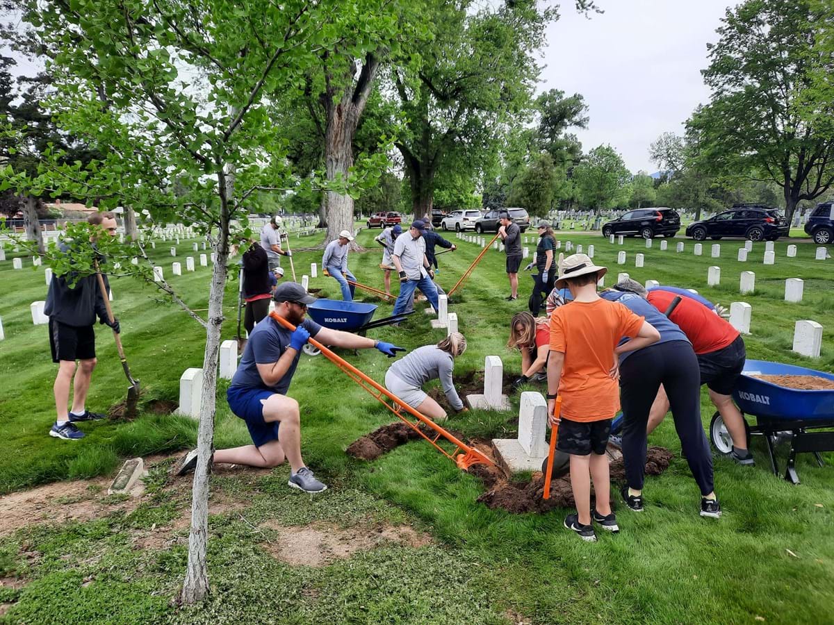 group at cemetery cleaning around tombstones