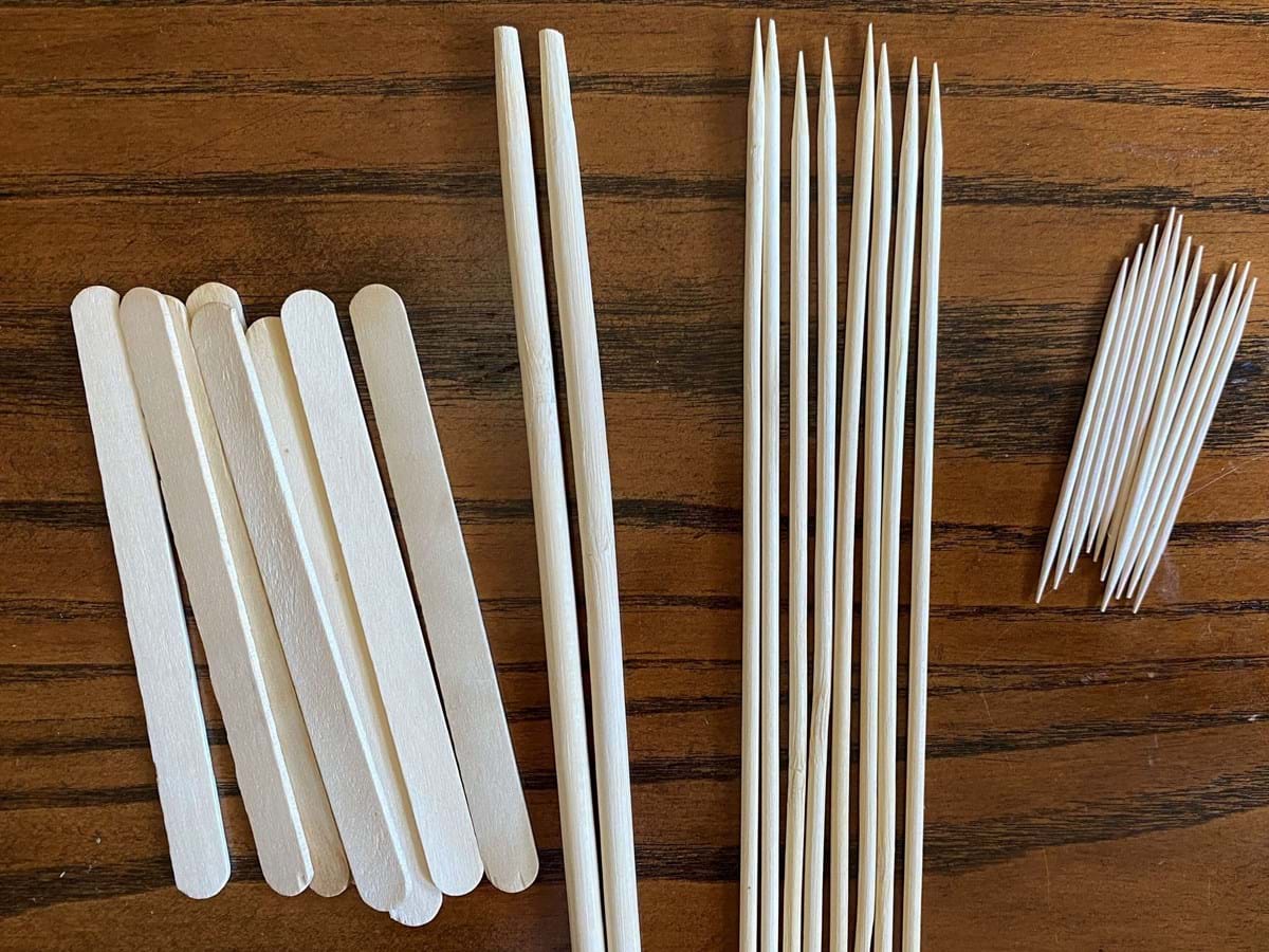 Wooden popsicle sticks, skewers and toothpicks on a wood table