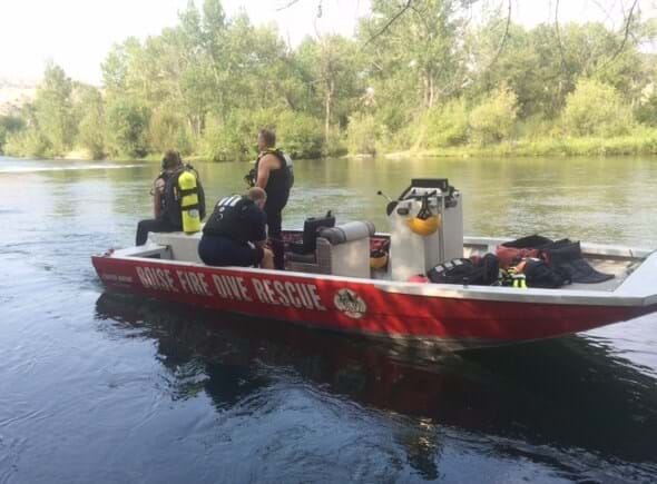 Boat in river with words "Boise Fire Dive Rescue" with three firefighters on board