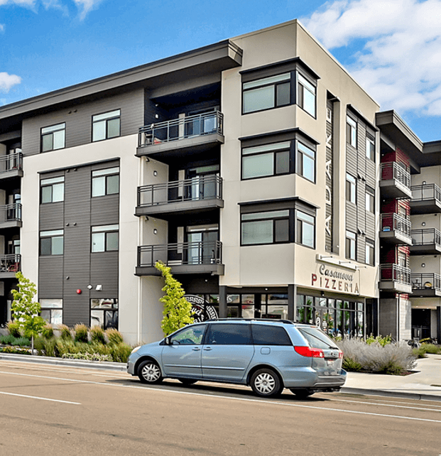 Four story modern residential building with car parked in front