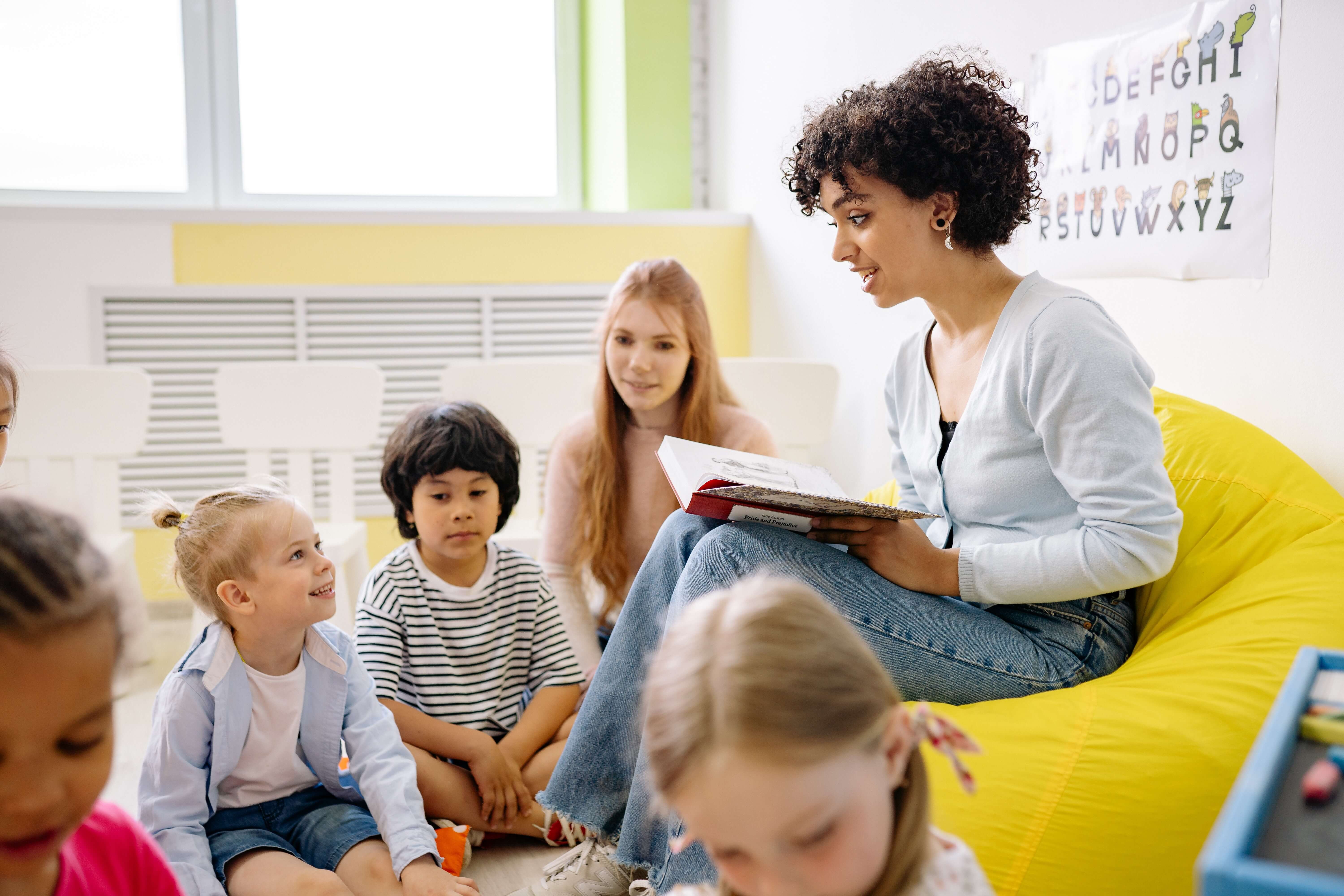 A childcare worker reads to children.