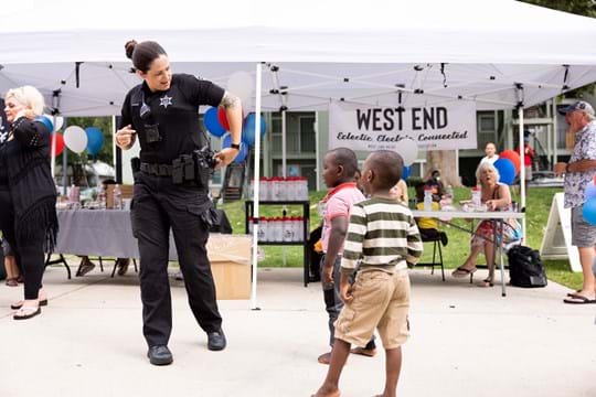 Woman officer dancing with young children