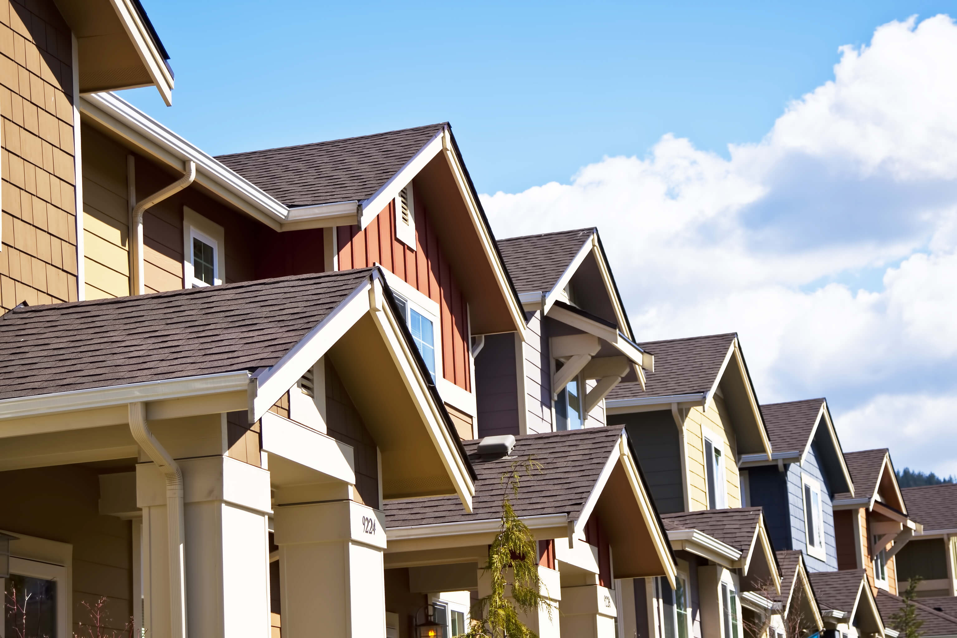A row of townhomes with blue skies in the background.