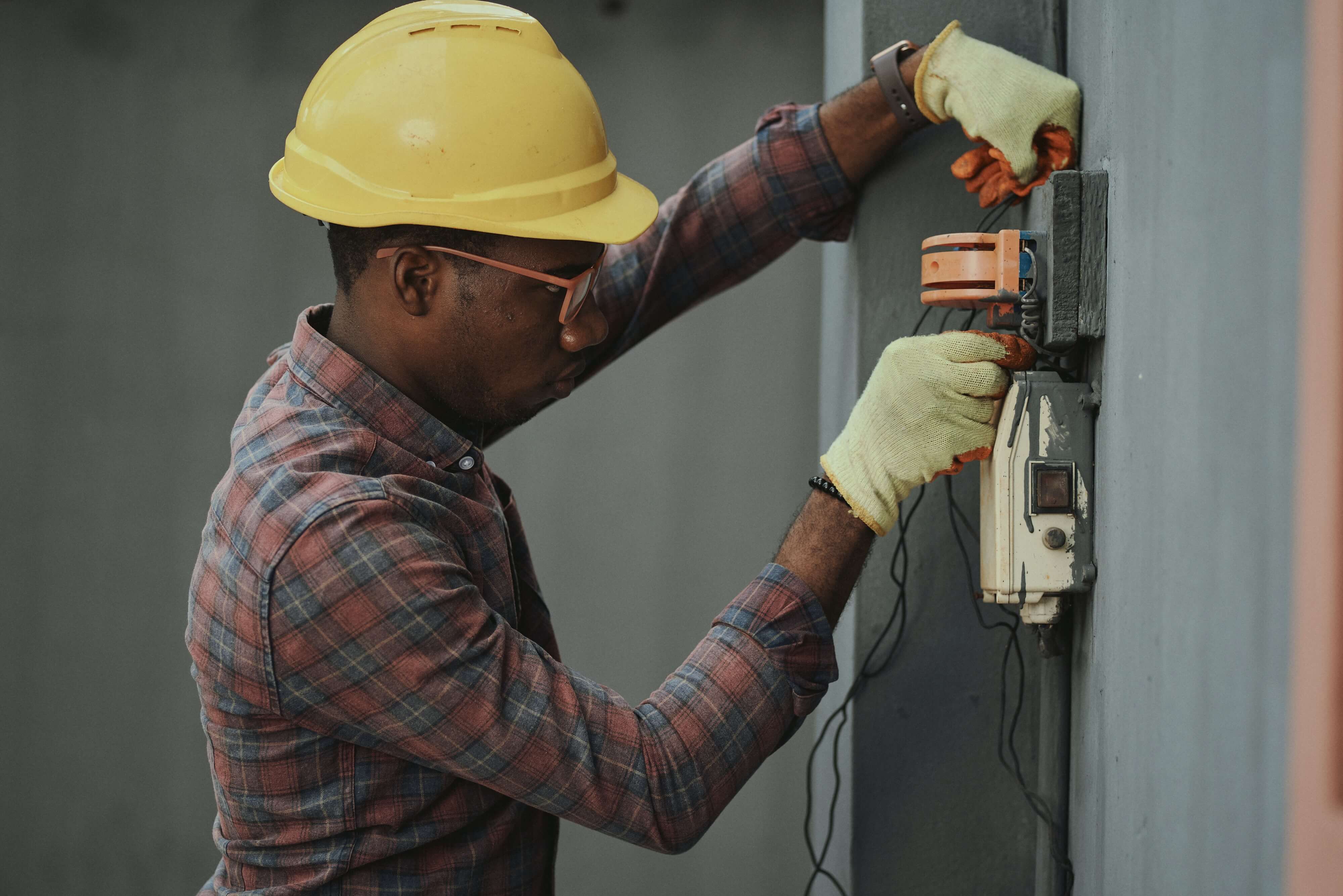 An electrician works on machinery.