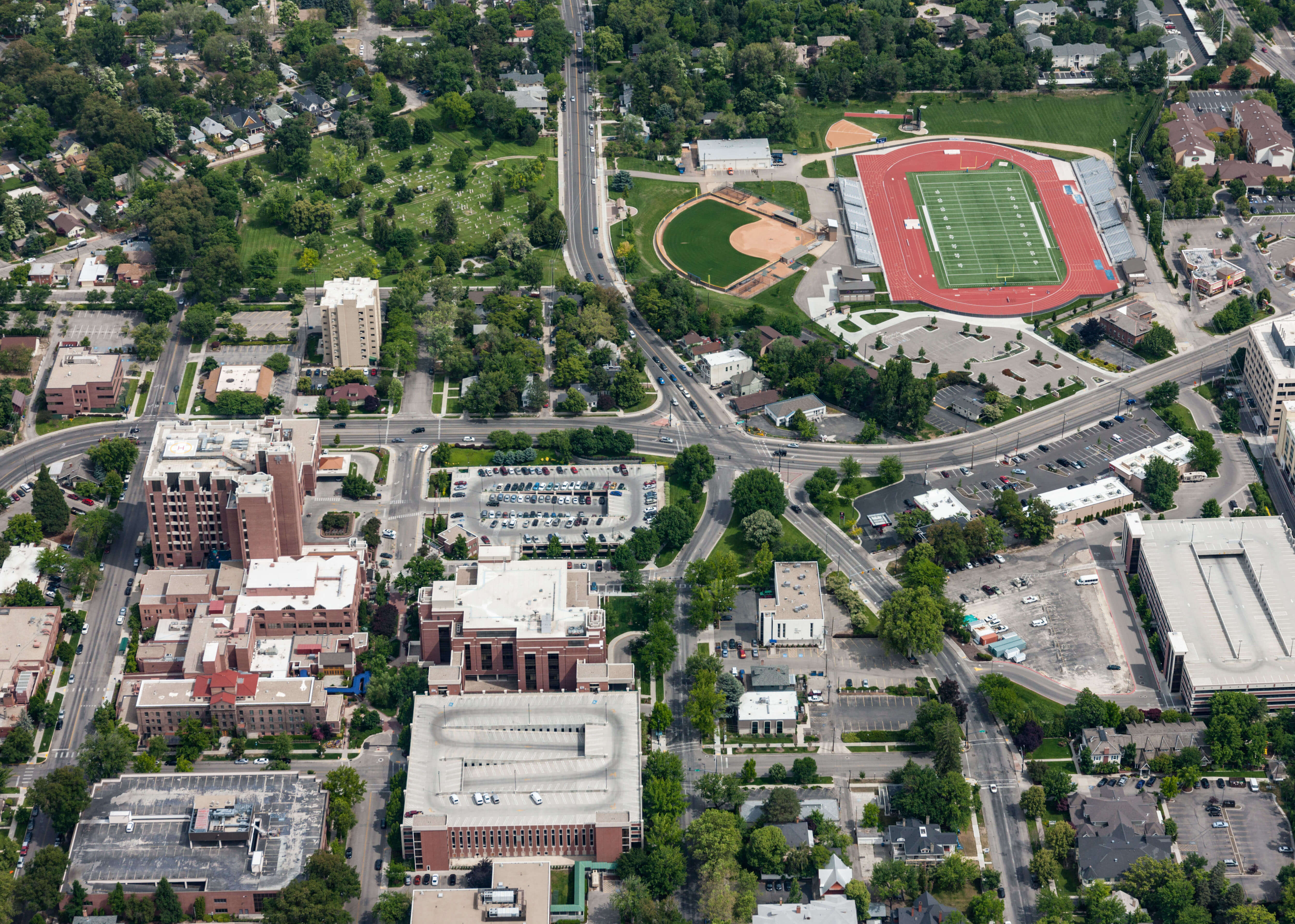 Arial view of roads and buildings around field stadium.