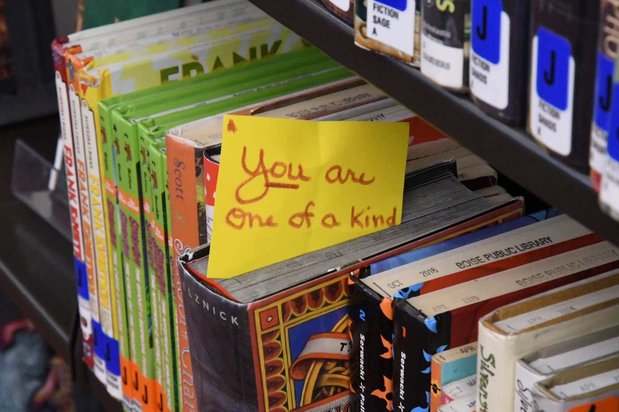Shelf of books with a note that says you are one of a kind.