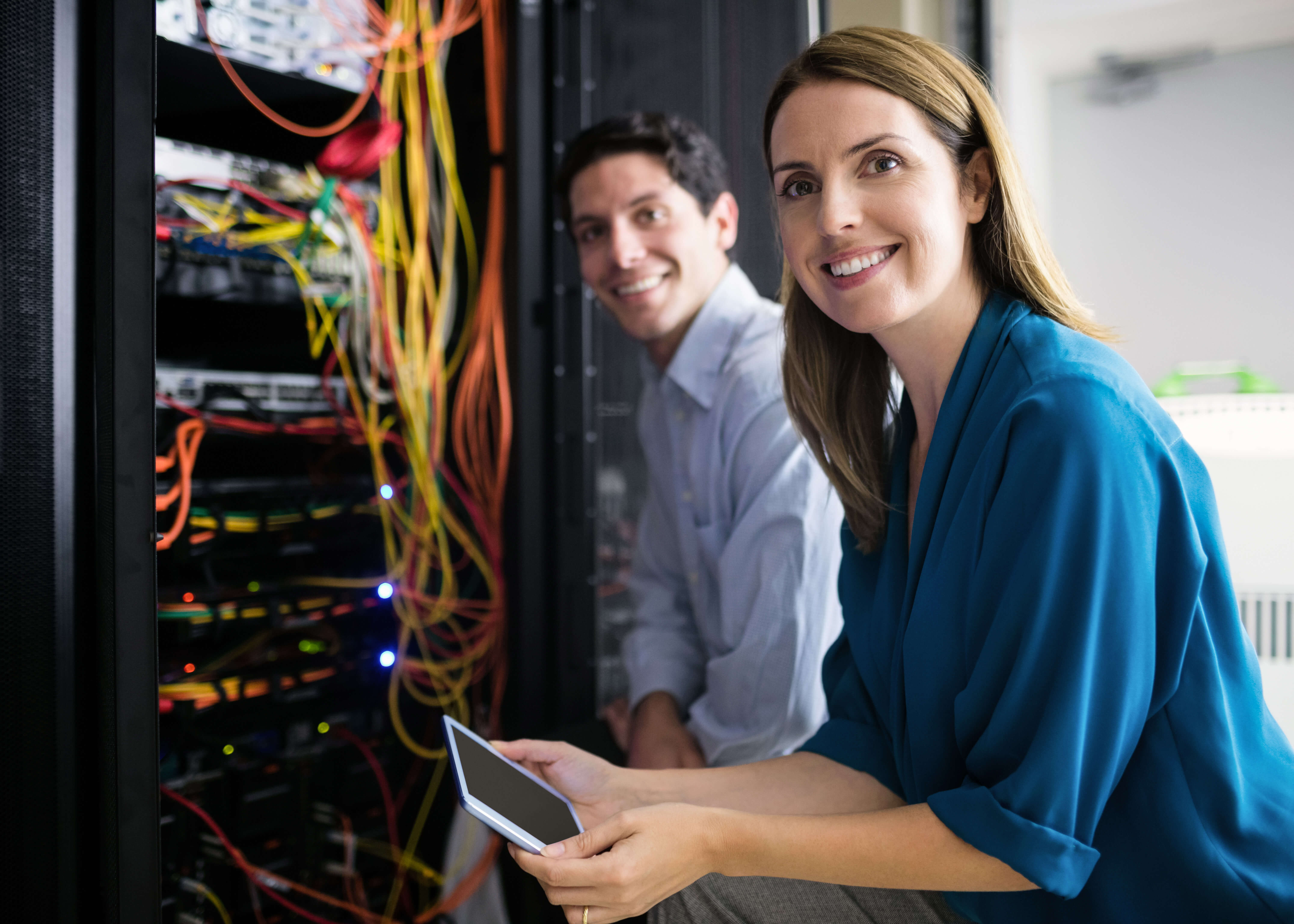 Two people work on a server.