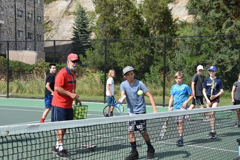 Group of youth and instructor learning tennis at Ann Morrison Park
