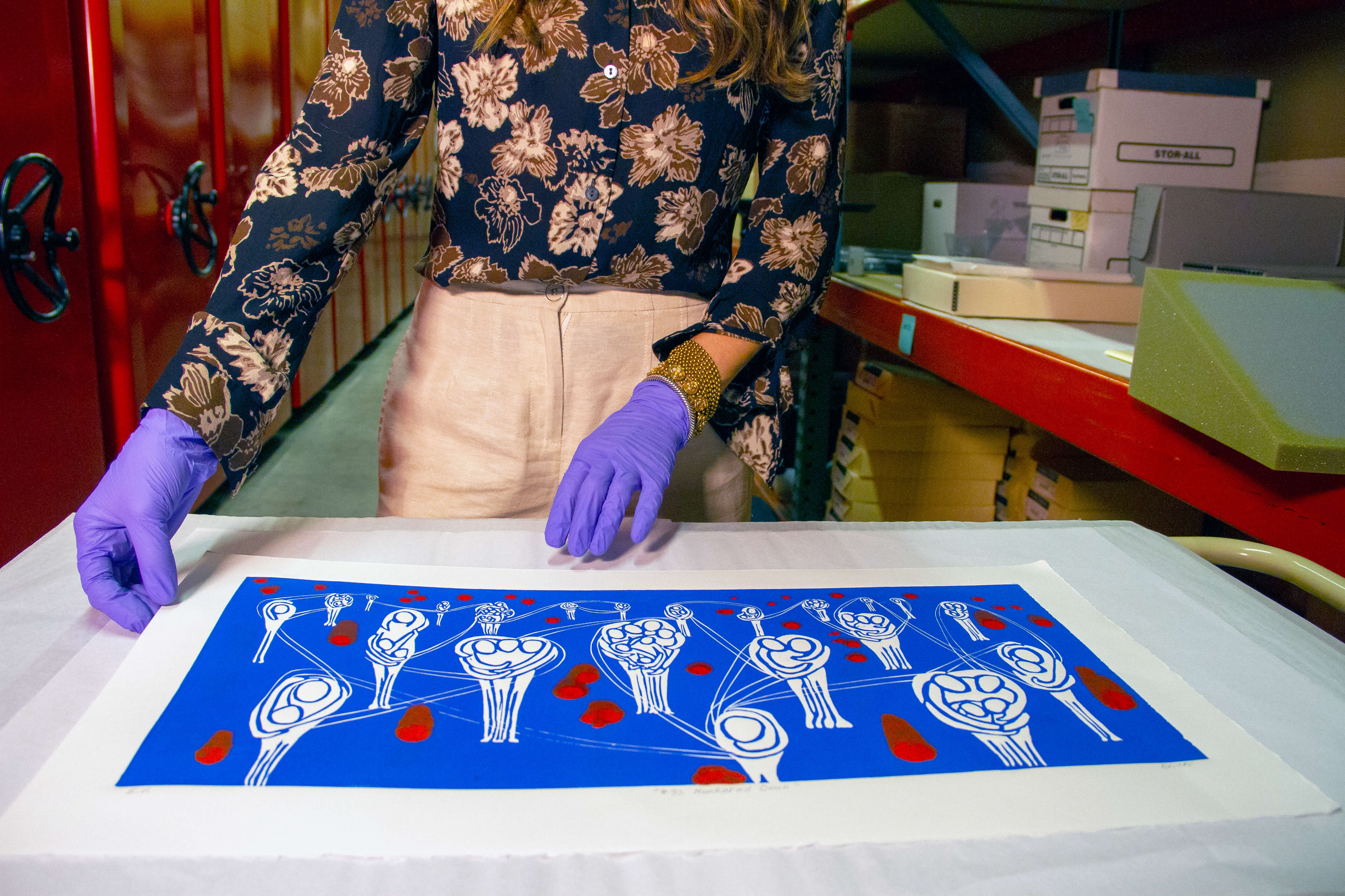 Person wearing gloves working on a piece of art.