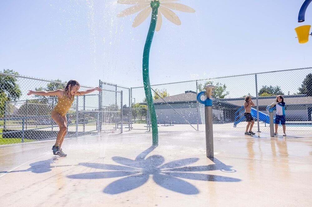young kids playing at the splash pad at borah pool on a hot summer day