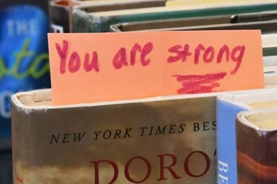 Book with a paper sticking out the top that says You are Strong
