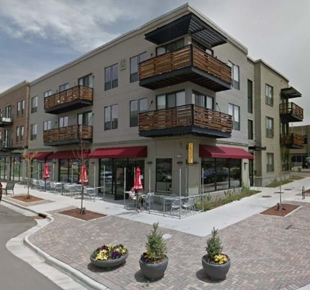 Street view image of three-story building with residential units occupying the top two floors and commercial use on the first floor exemplifying the MX-3 district.