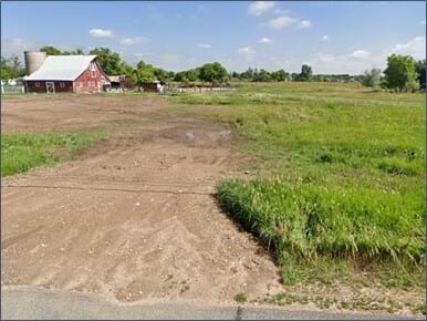 Street view of open land with single barn and open field space exemplifying the A-1 district. 