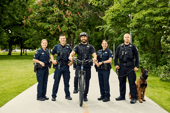 Five officers standing outside on a paved path