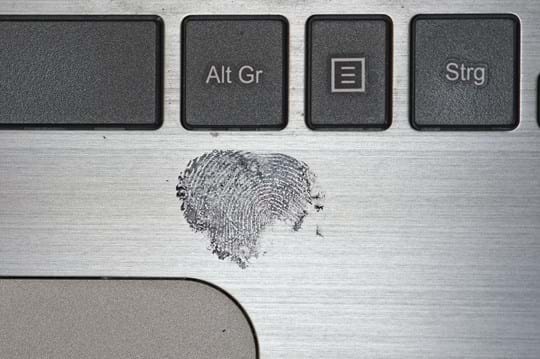Black, dusted fingerprint on a laptop computer.