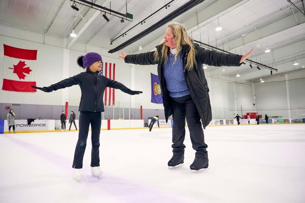 Young girl taking a lesson from an instructor at Idaho IceWorld