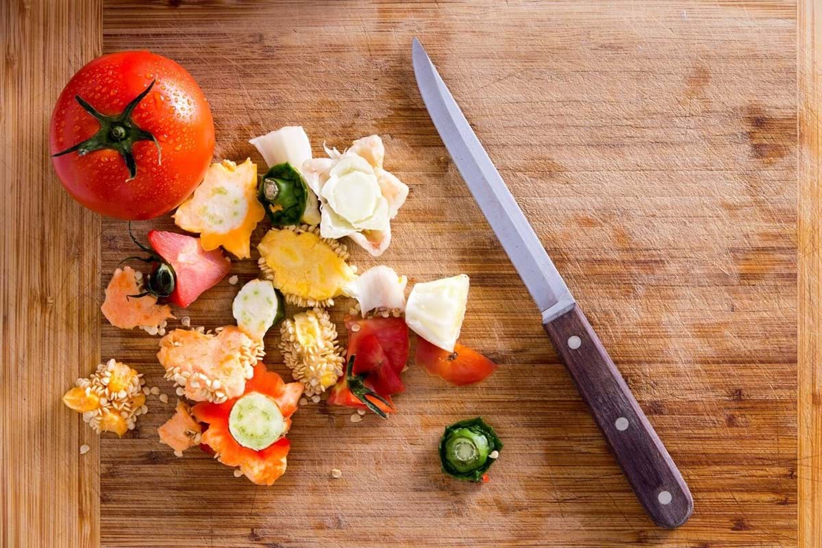 chopped vegetables next to a knife on a wood cutting board