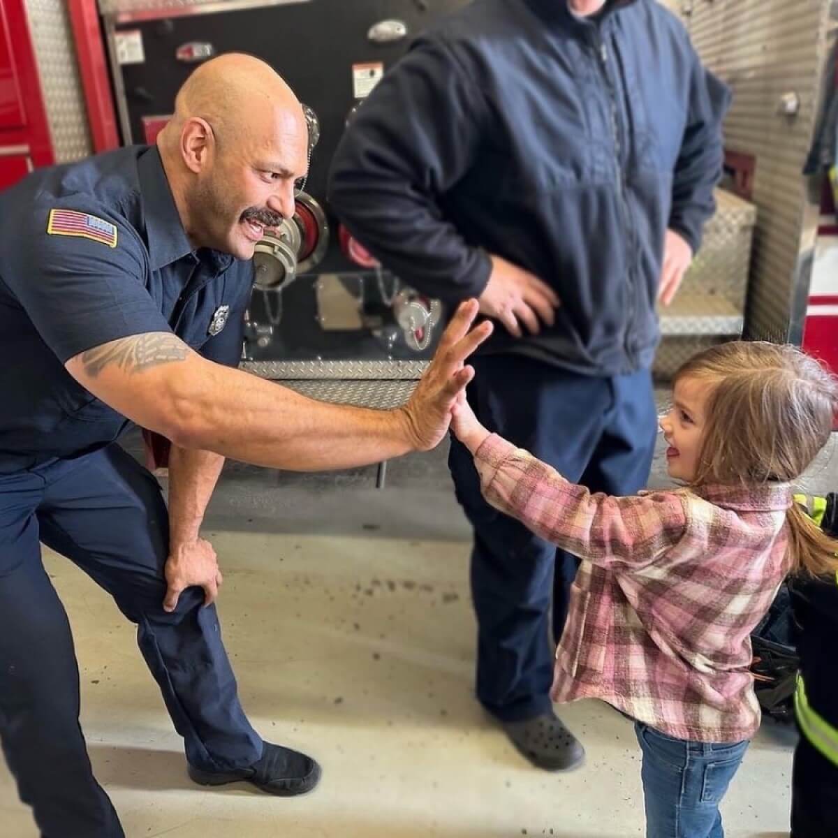 Firefighter giving a small child a high five.