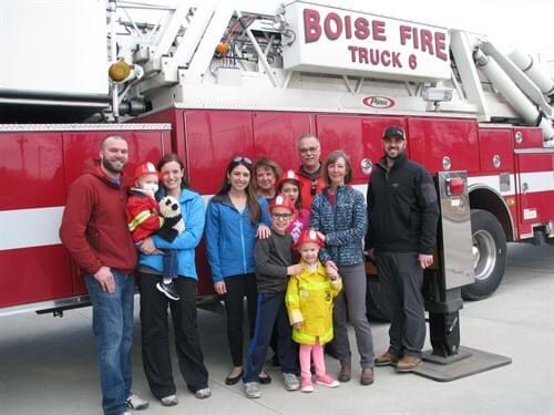 Group of 7 adults and 4 children stand in front of Boise Fire Truck 6