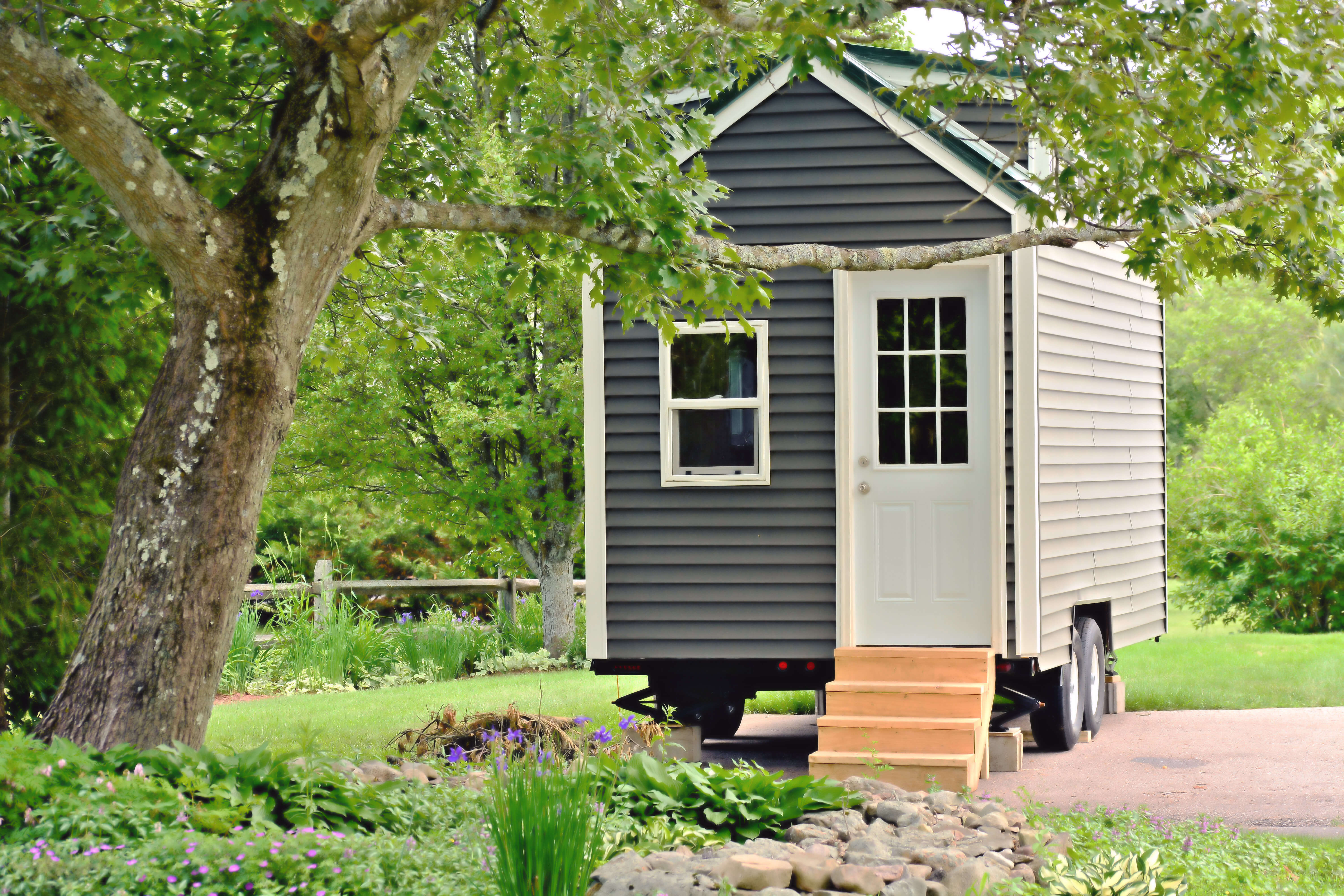 Tiny house with green grass and stairs leading to the front door.