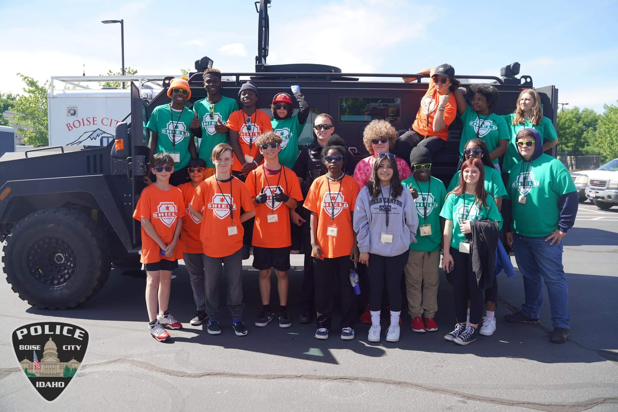 A group poses in front of a police vehicle