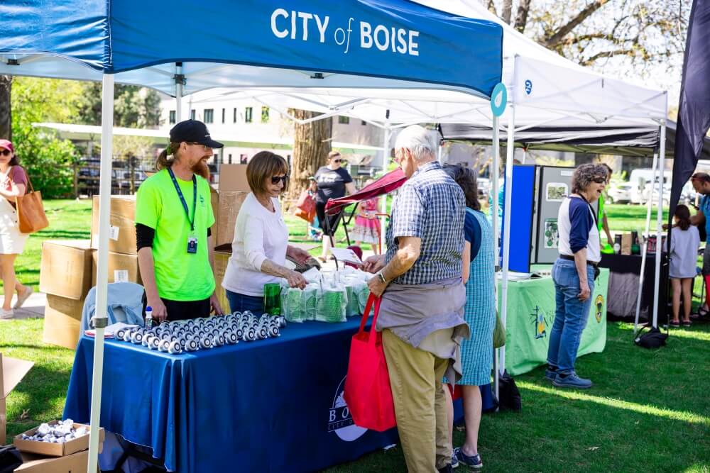 People standing at an Earth Day booth giving out swag.