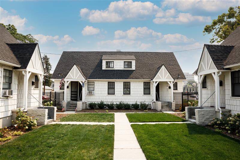 White cottage-style houses with a common area in front.