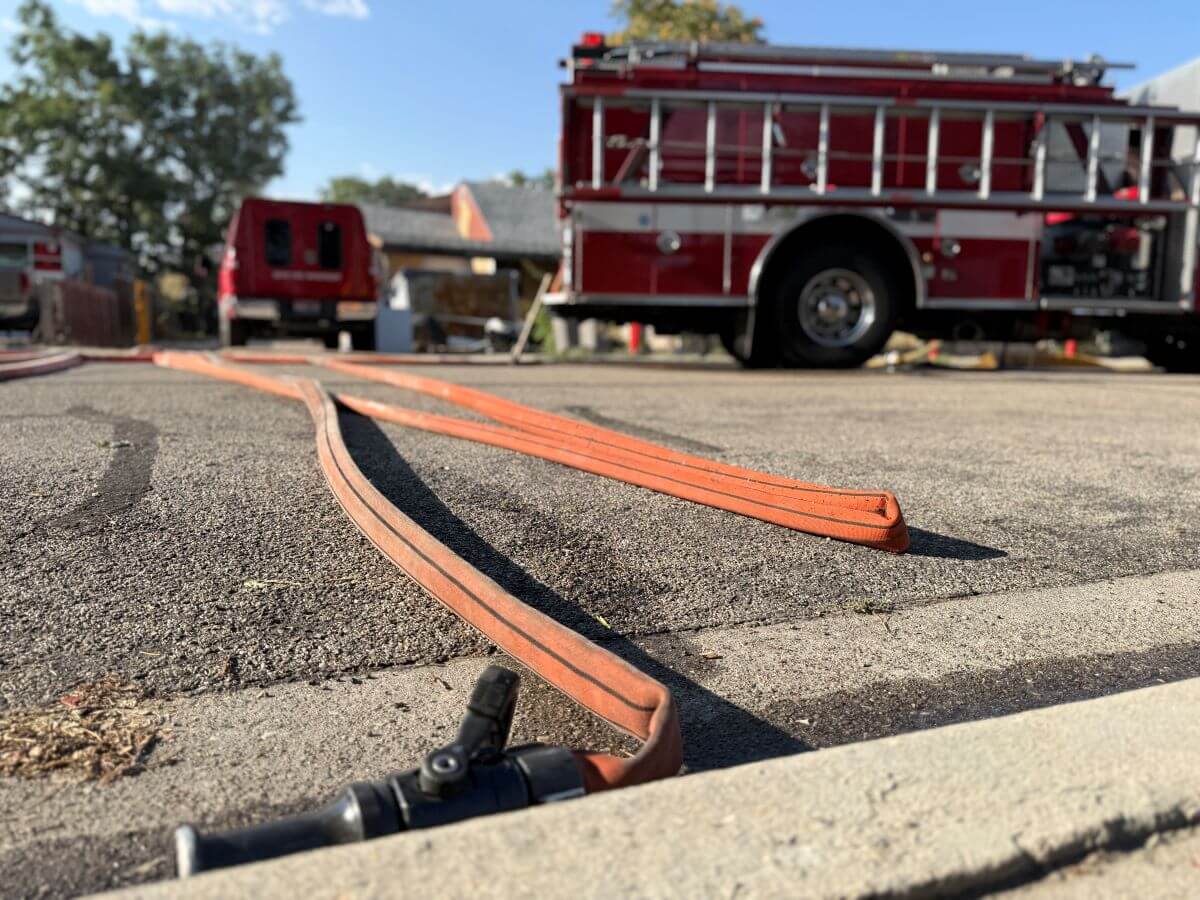 Fire truck with hose on the street.