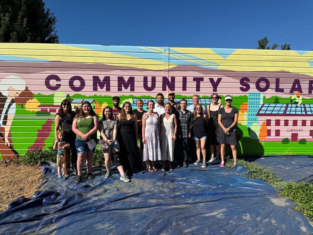 Community members stand in front of public art piece.